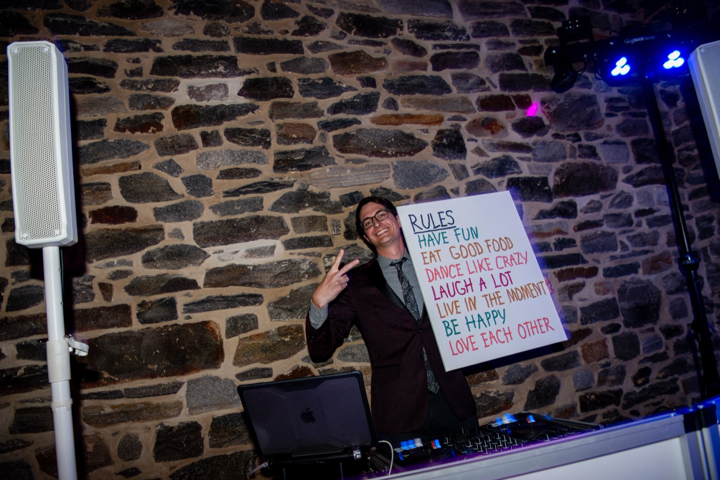 Jeff at the booth holding a handwritten sign of wedding rules